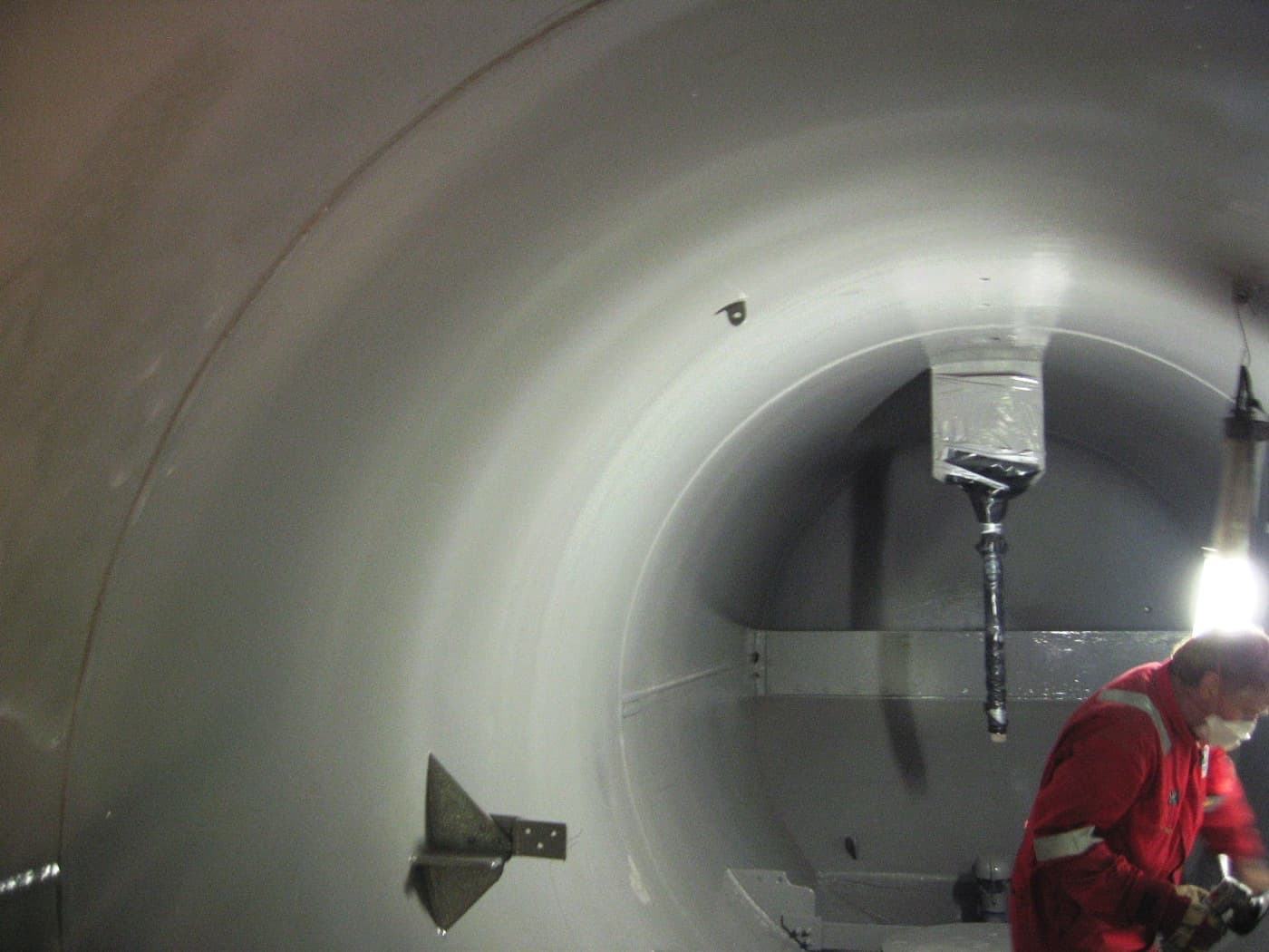 Coatings technician applying a Belzona lining inside a process vessel, in situ